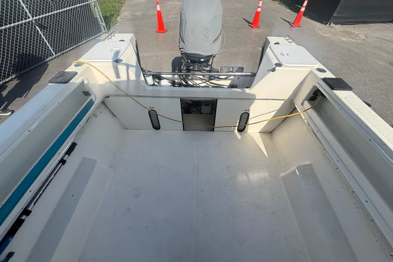 Slide: The Image of 2013 C-Dory 22' Cruiser boat interior with clean deck and motor, parked near traffic cones. - 25
