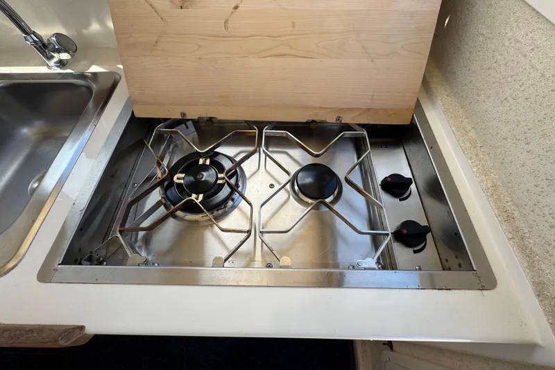 Slide: The Image of A stainless steel two-burner cooktop next to a sink in a boat's galley. - 26