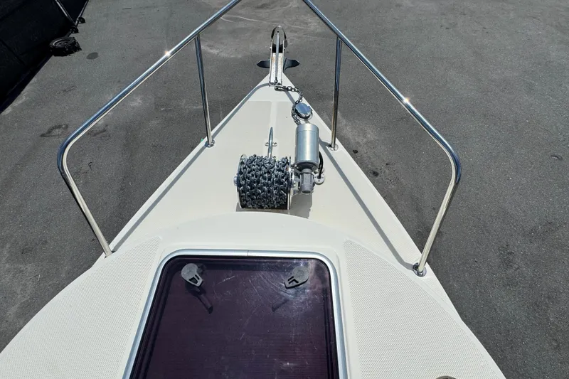 Slide: The Image of 2013 C-Dory 22' Cruiser bow with anchor and hatch, docked on pavement. - 21