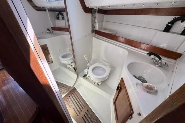Slide: The Image of Interior of 1990 J Boats J/37 yacht bathroom with toilet, sink, and wooden accents. - 22