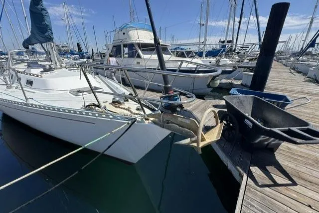 Slide: The Image of 1990 J Boats J/37 sailboat docked at marina, surrounded by other vessels. - 2