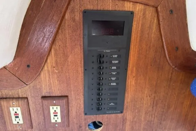 Slide: The Image of Electrical panel on 1990 J Boats J/37 sailboat with wooden interior and power outlets. - 29