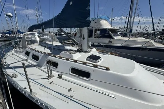Slide: The Image of 1990 J Boats J/37 sailboat docked in a marina, featuring sleek white design and blue sail. - 4