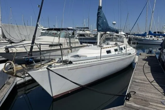 The Image of 1990 J Boats J/37 sailboat docked at marina, surrounded by other vessels. - 0