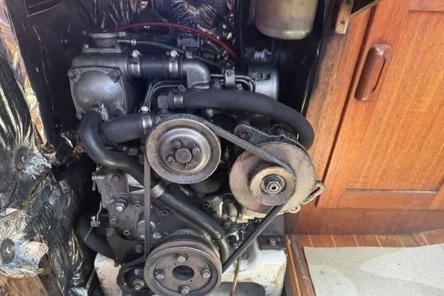 Slide: The Image of Engine compartment of a 1990 J Boats J/37 sailboat, showcasing mechanical components and belts. - 30