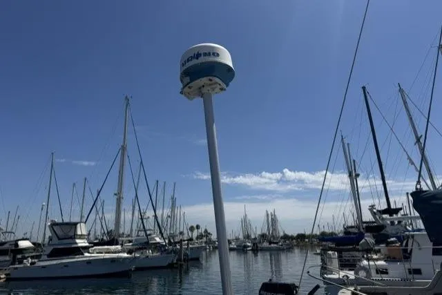 Slide: The Image of Marina with sailboats, featuring a 1990 J Boats J/37 under a clear blue sky. - 7