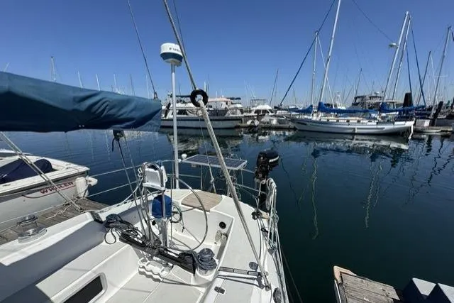 Slide: The Image of Sailboat docked in marina, 1990 J Boats J/37, surrounded by other vessels under clear blue sky. - 3
