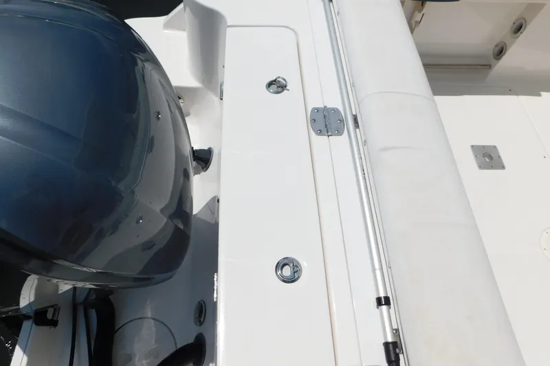 Slide: The Image of 2018 Robalo R247 Dual Console boat deck with motor and seating area. - 9