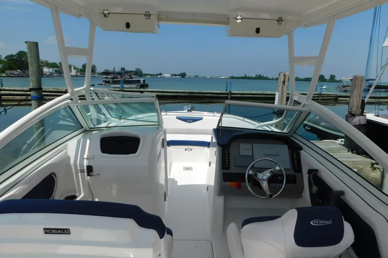 Slide: The Image of 2018 Robalo R247 Dual Console boat interior with steering wheel and Garmin navigation system. - 15