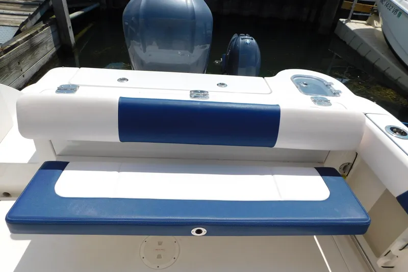 Slide: The Image of 2018 Robalo R247 Dual Console boat with blue and white seating at the stern. - 21