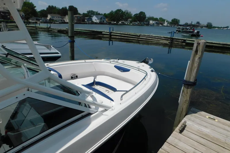 Slide: The Image of 2018 Robalo R247 Dual Console boat docked by a serene waterfront. - 7