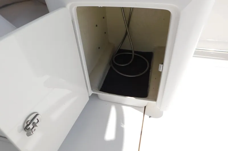 Slide: The Image of Open storage compartment on a 2018 Robalo R247 Dual Console boat. - 17