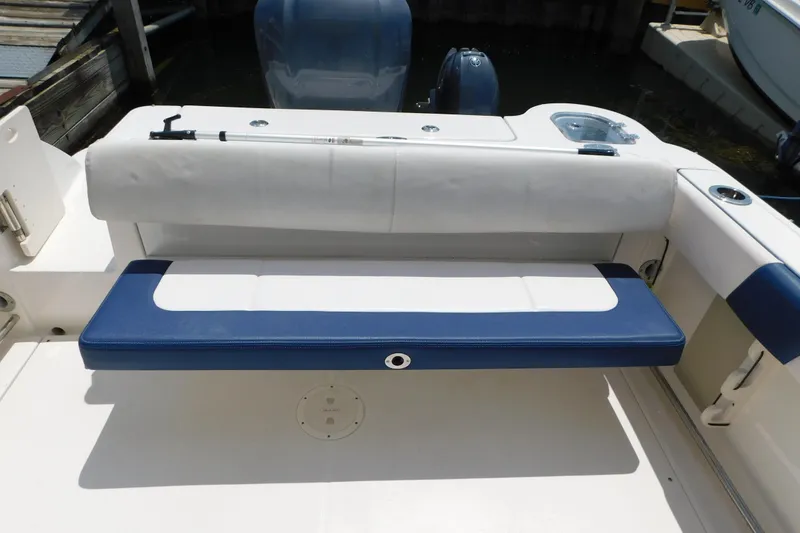 Slide: The Image of 2018 Robalo R247 Dual Console boat with blue and white seating at the stern. - 19