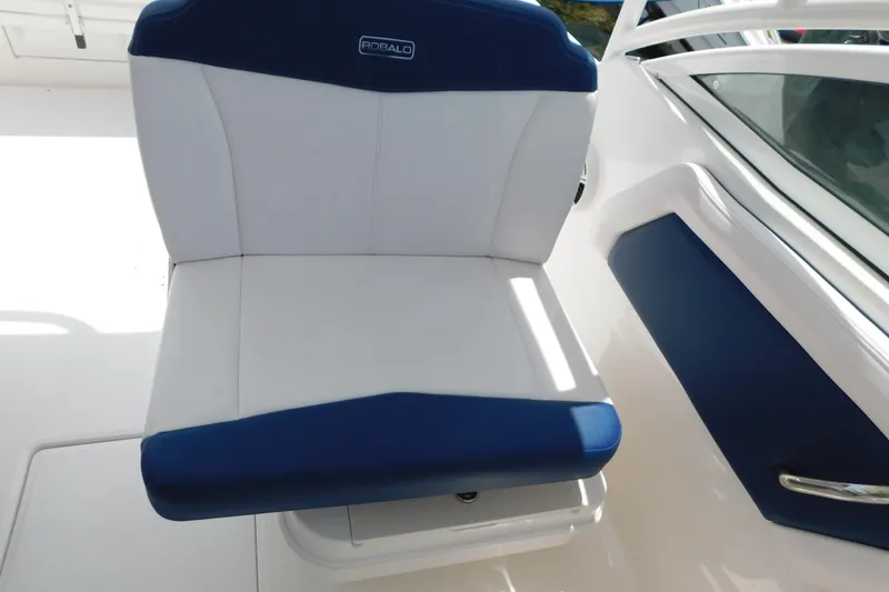 Slide: The Image of 2018 Robalo R247 Dual Console boat seat with blue and white upholstery. - 72