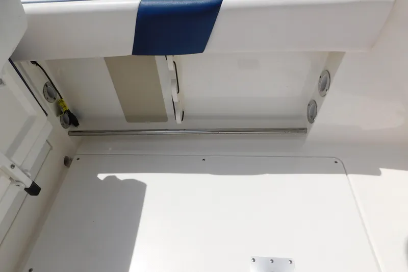 Slide: The Image of 2018 Robalo R247 Dual Console interior detail, featuring storage compartment and seating area. - 73