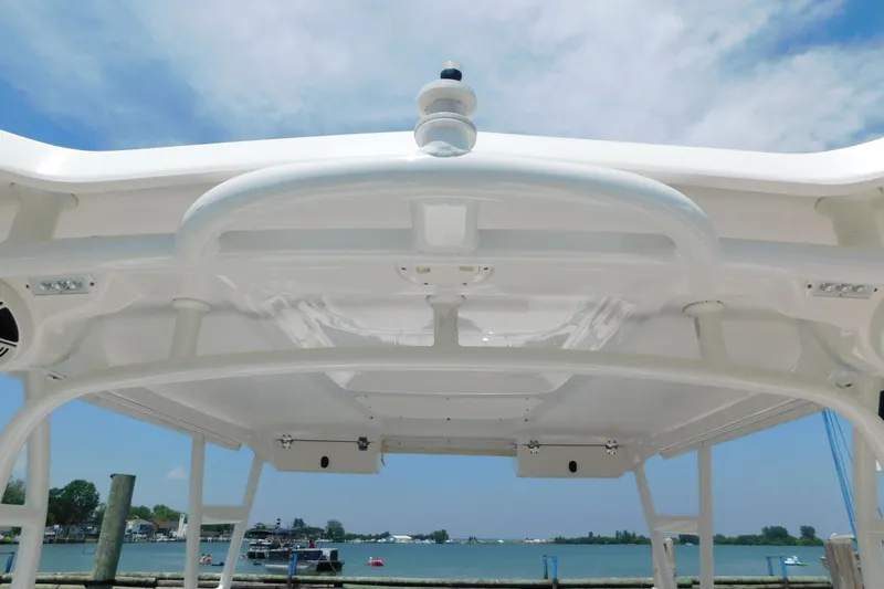 Slide: The Image of 2018 Robalo R247 Dual Console boat roof with clear sky and waterfront view. - 22