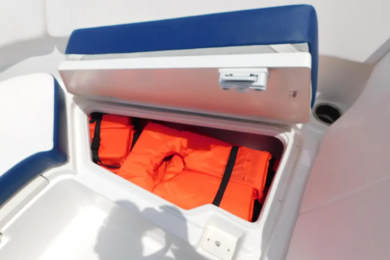 Slide: The Image of Storage compartment with life jackets on a 2018 Robalo R247 Dual Console boat. - 55