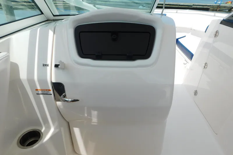 Slide: The Image of 2018 Robalo R247 Dual Console interior with sleek white finish and storage compartment. - 45