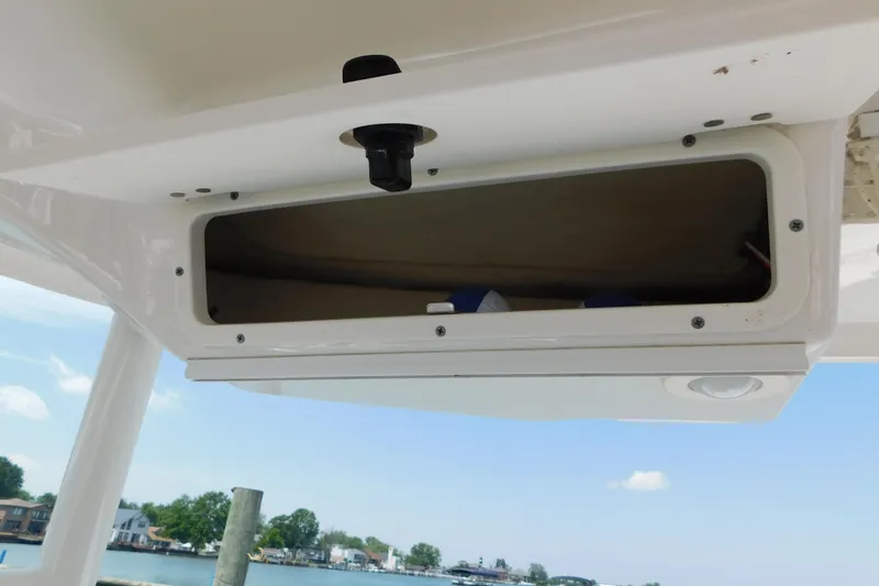 Slide: The Image of Open storage compartment on a 2018 Robalo R247 Dual Console boat. - 70