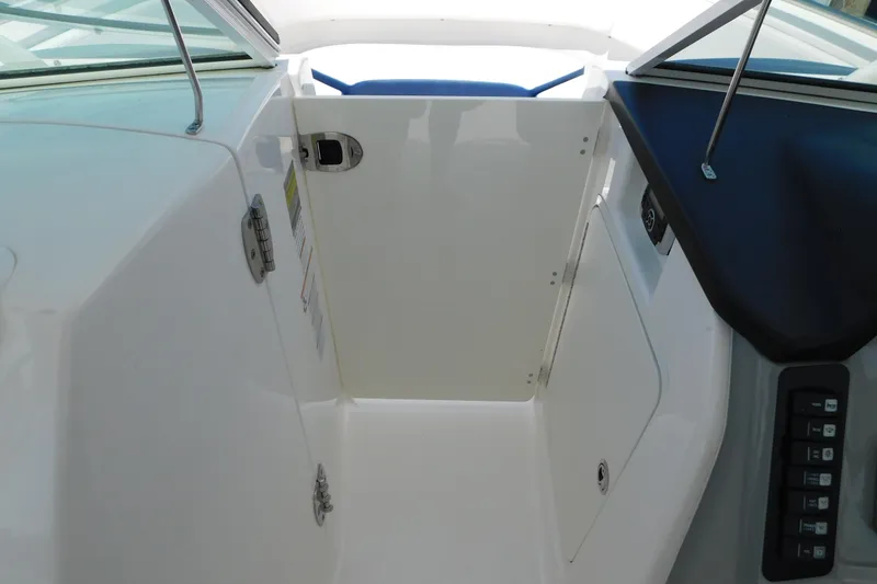Slide: The Image of 2018 Robalo R247 Dual Console interior with open door and control panel. - 49