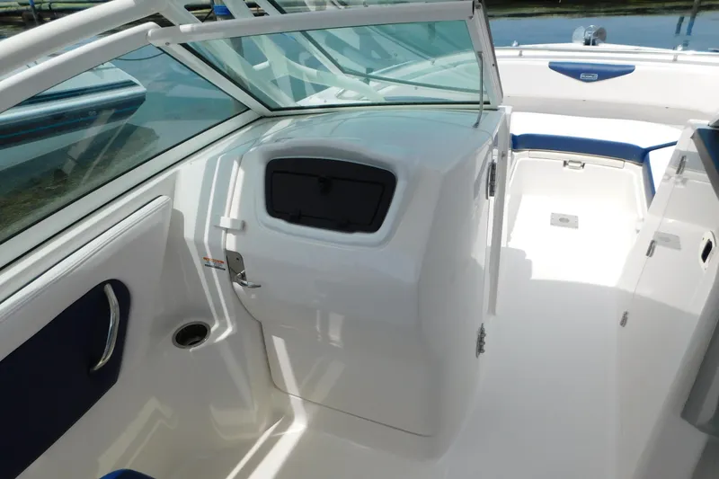 Slide: The Image of 2018 Robalo R247 Dual Console boat interior with white and blue seating, open deck view. - 38