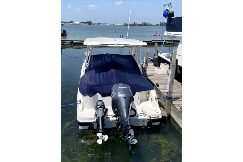 Slide: The Image of 2018 Robalo R247 Dual Console boat docked with covered seating area. - 75