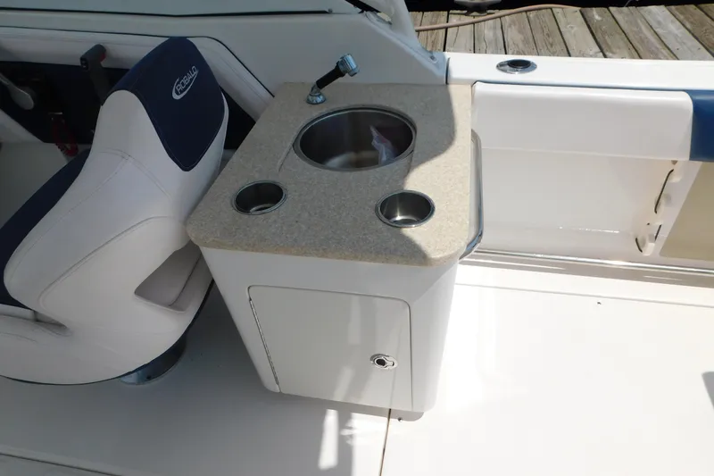Slide: The Image of 2018 Robalo R247 Dual Console boat interior with sink and seating area. - 16