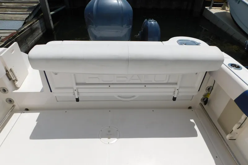 Slide: The Image of 2018 Robalo R247 Dual Console boat interior with seating and engine view. - 18