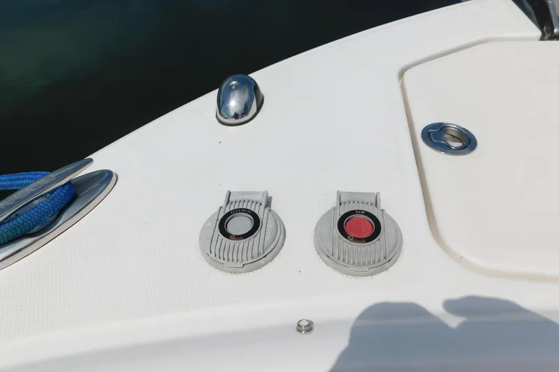 Slide: The Image of 2018 Robalo R247 Dual Console boat deck with cleats and control buttons. - 61