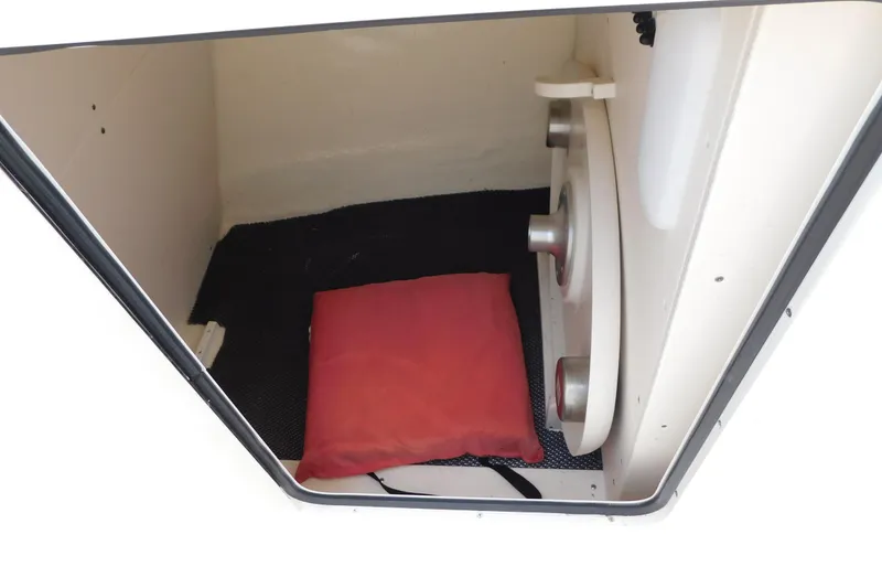 Slide: The Image of Interior storage compartment of 2018 Robalo R247 Dual Console boat with red cushion. - 51