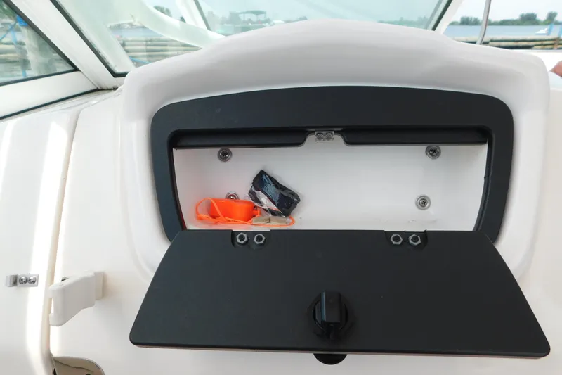 Slide: The Image of Open storage compartment on 2018 Robalo R247 Dual Console boat dashboard. - 40