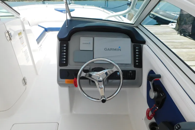 Slide: The Image of 2018 Robalo R247 Dual Console helm with Garmin navigation system and steering wheel. - 25