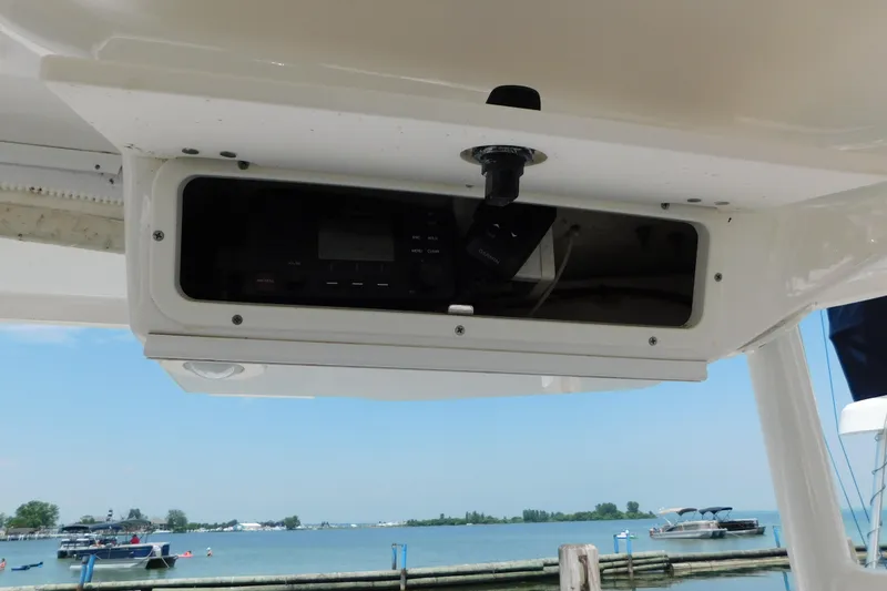 Slide: The Image of 2018 Robalo R247 Dual Console boat with electronic compartment, docked by a scenic waterfront. - 26