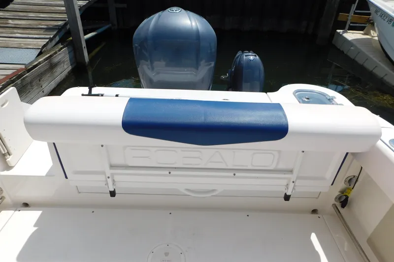 Slide: The Image of 2018 Robalo R247 Dual Console boat with blue and white seating at the stern. - 20