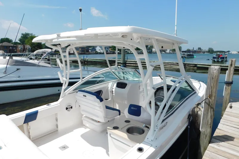 Slide: The Image of 2018 Robalo R247 Dual Console boat docked by the waterfront on a sunny day. - 2