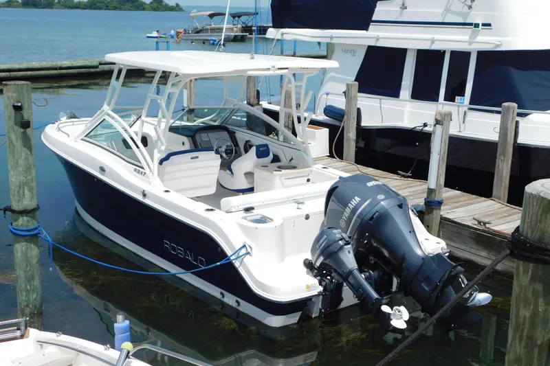 Slide: The Image of 2018 Robalo R247 Dual Console boat docked with Yamaha outboard motor. - 6