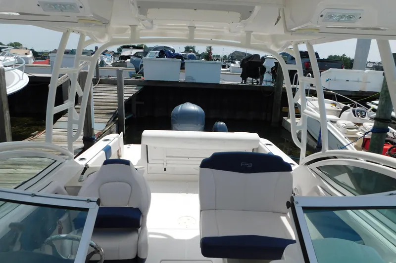 Slide: The Image of 2018 Robalo R247 Dual Console boat docked, featuring spacious seating and modern design. - 67