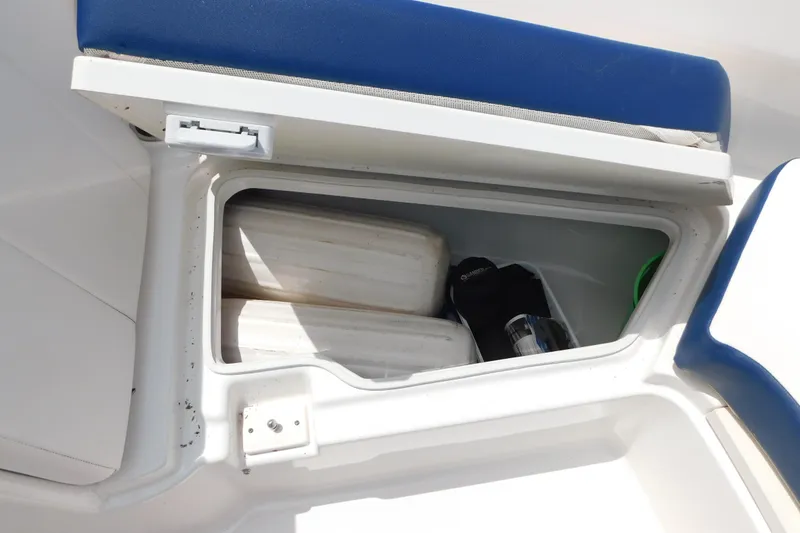 Slide: The Image of Storage compartment on a 2018 Robalo R247 Dual Console boat with blue seating. - 59