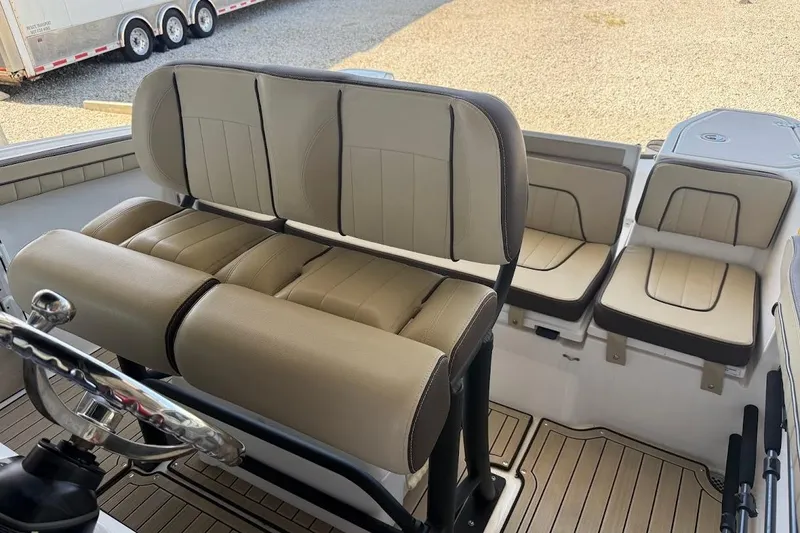 Slide: The Image of 2024 Yamaha Boats 255 FSH Sport H interior seating with beige upholstery and steering wheel. - 15