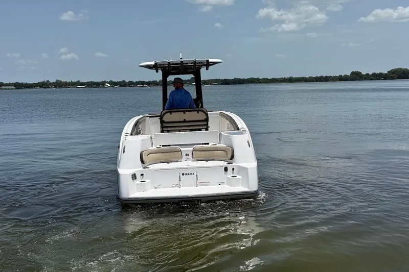 Slide: The Image of 2024 Yamaha Boats 255 FSH Sport H cruising on a calm lake. - 4
