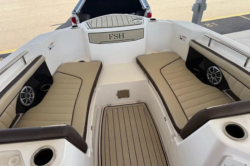Slide: The Image of 2024 Yamaha Boats 255 FSH Sport H interior with beige seating and speakers. - 10