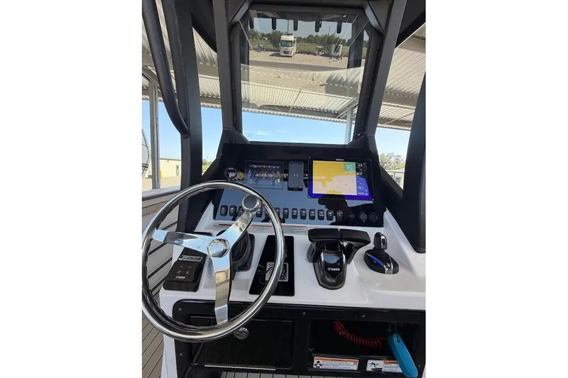 Slide: The Image of 2024 Yamaha Boats 255 FSH Sport H dashboard with steering wheel and navigation controls. - 26
