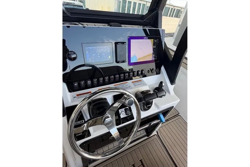 Slide: The Image of 2024 Yamaha Boats 255 FSH Sport H dashboard with steering wheel and navigation screens. - 25