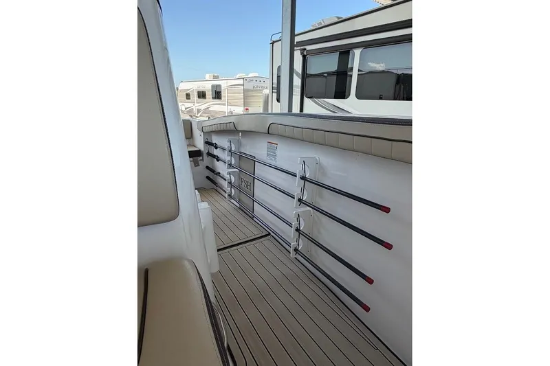 Slide: The Image of 2024 Yamaha Boats 255 FSH Sport H interior with rod holders and sleek design. - 22