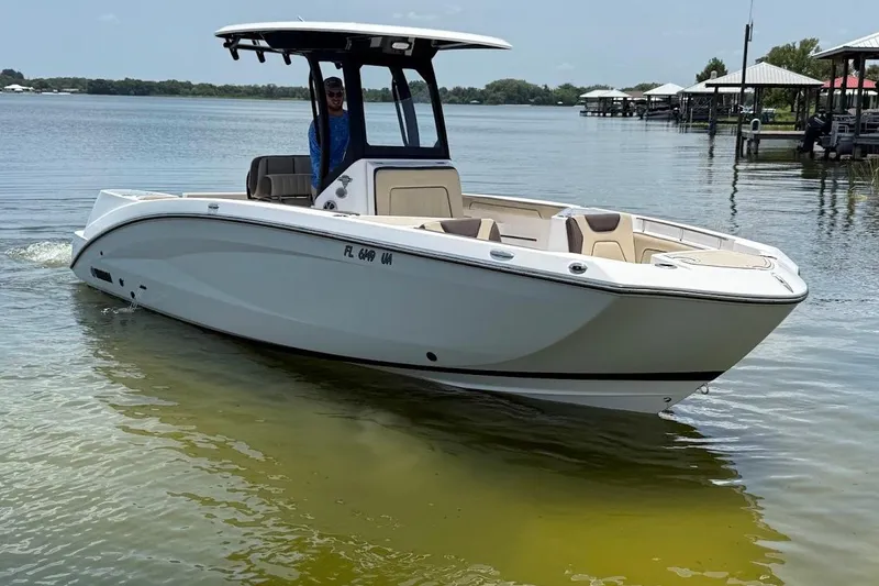 Slide: The Image of 2024 Yamaha Boats 255 FSH Sport H on calm water, showcasing sleek design and modern features. - 2