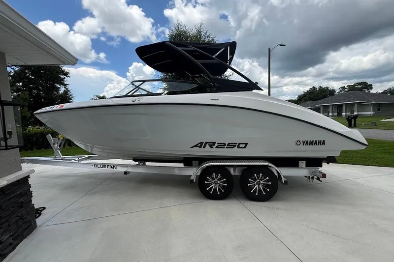 Slide: The Image of 2025 Yamaha Boats AR250 on trailer, parked outdoors under cloudy sky. - 3