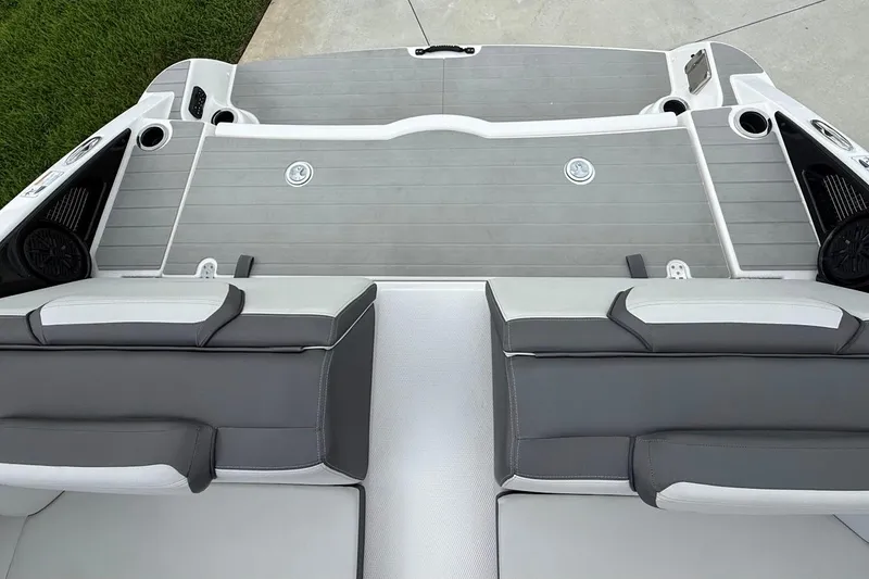 Slide: The Image of 2025 Yamaha Boats AR250 interior with gray seating and deck, featuring cup holders and speakers. - 24