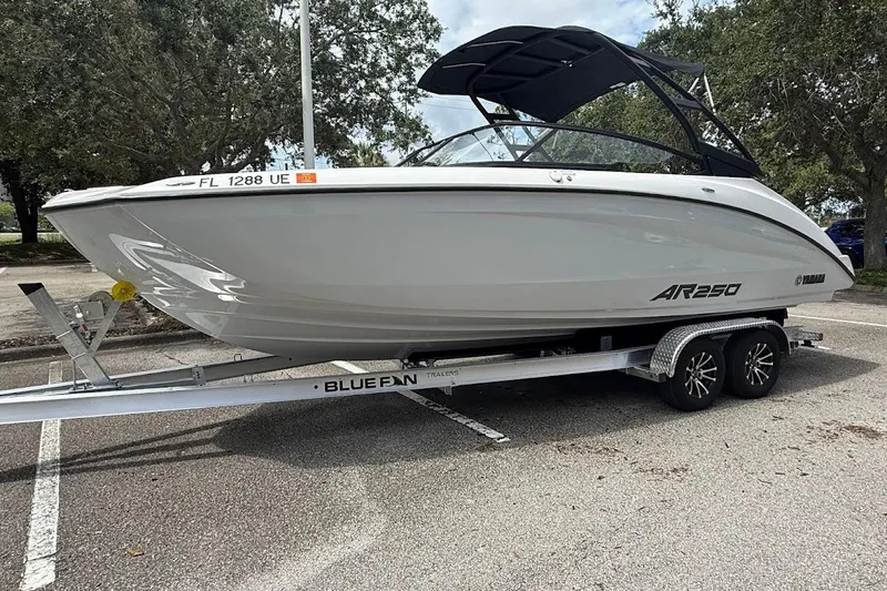 Slide: The Image of 2025 Yamaha Boats AR250 on trailer, parked outdoors, showcasing sleek design and modern features. - 2