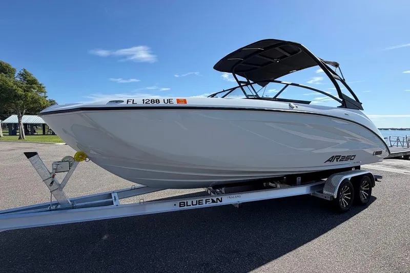Slide: The Image of 2025 Yamaha AR250 boat on trailer, parked outdoors under clear blue sky. - 31