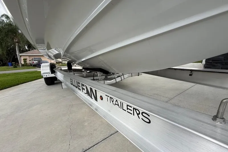 Slide: The Image of 2025 Yamaha Boats AR250 on Bluefin trailer, parked in a residential driveway. - 28